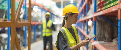 Donna che controlla Scaffali di magazzino